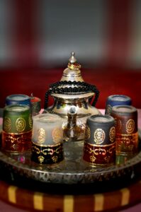 A beautifully decorated Moroccan tea set featuring ornate glasses and a traditional teapot.